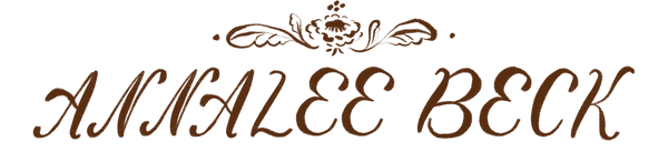 Brown cursive text reading 'ANNALEE BECK' with an ornate floral crest above, shown on a plain white background.